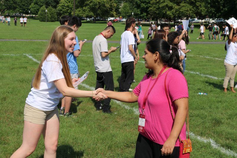 Two female students shaking hands