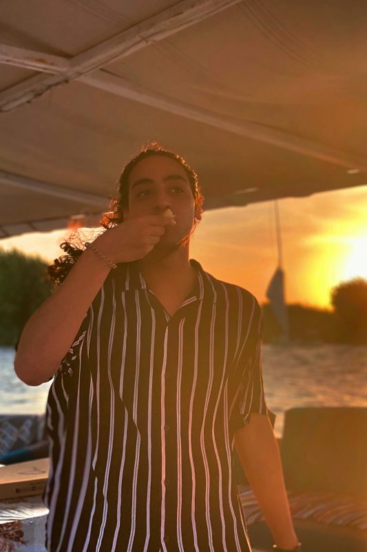 A man standing on a boat eating